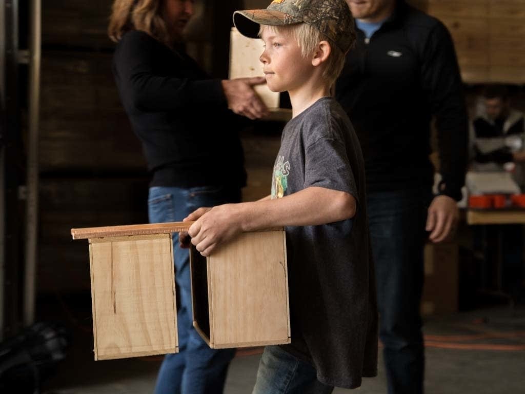 Jesse Koskiniemi concentrates as he carries two crates full of bees.