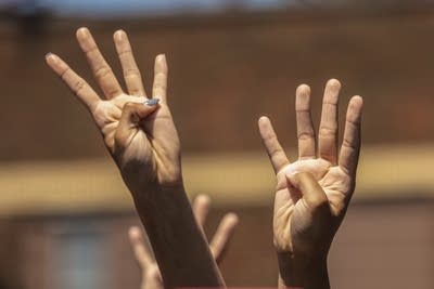 People hold up four fingers