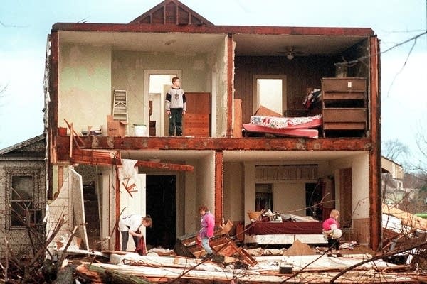 Family members search for the family cat shortly after a tornado.