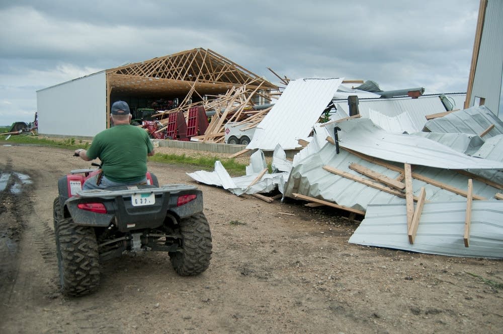 Robert Nienow drives past one of his damaged sheds