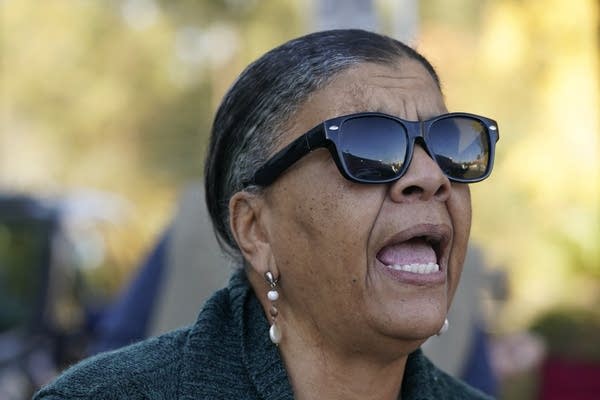 A woman speaks outside.