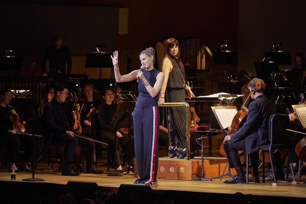 Dessa holds a microphone onstage at Orchestra Hall.