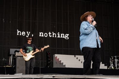 Two musicians performing on a large outdoor stage