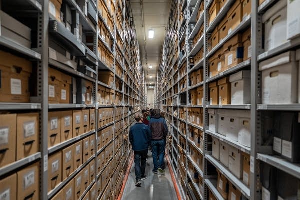 People walk through shelves of archives