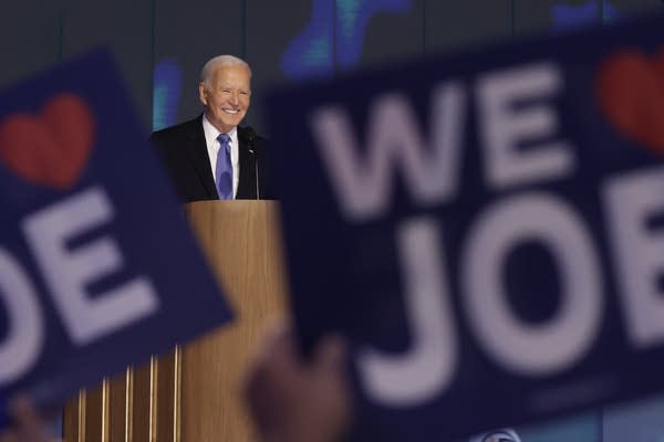 Joe Biden at a podium behind "We Love Joe" signs