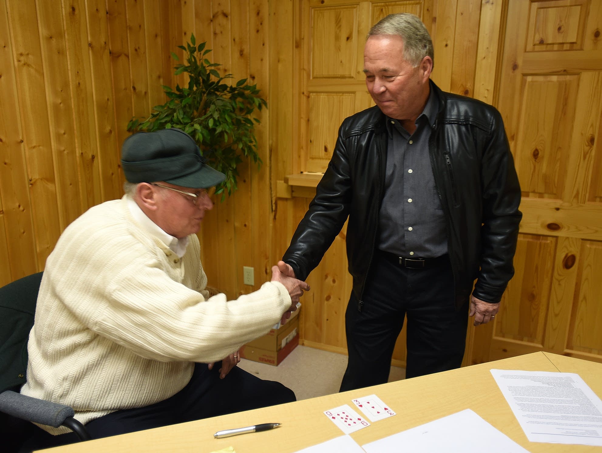 Larson extended a hand to Allen after a card draw reelected Allen mayor.