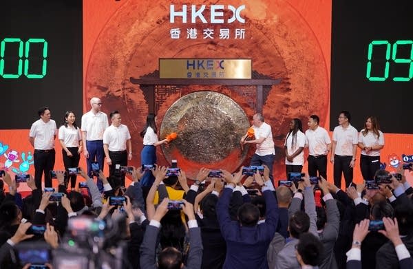 Customers and partners of Alibaba Group strike a gong during the company's listing ceremony at the Hong Kong Stock Exchange