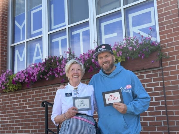 Two people standing in front of "You Matter" sign