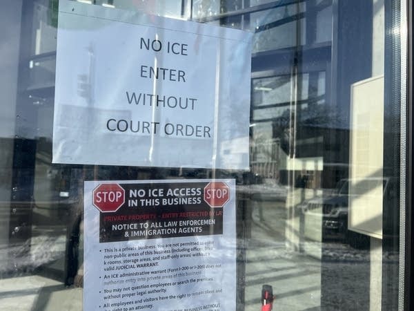 Signs posted on the inside of a glass door that read, "NO ICE ENTER WITHOUT COURT ORDER."