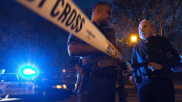 Rev. Lawrence Hubbard speaks with a police officer