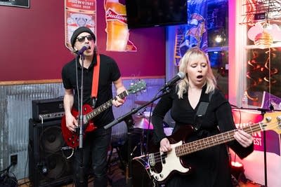 Two people performing by window