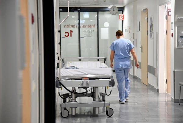 A medical staff walks past an empty bed on an intensive care unit (ICU) at a hospital of the Salzburg state clinics in Salzburg, Austria, on November 17, 2021, during the ongoing coronavirus (Covid-19) pandemic. - On November 15, Austria became the first EU country to lockdown the unvaccinated in a bid to halt spiralling virus infection rates of around 12,000 per day in the country of 8.9 million. - Austria OUT (Photo by BARBARA GINDL / APA / AFP) / Austria OUT (Photo by BARBARA GINDL/APA/AFP via Getty Images)