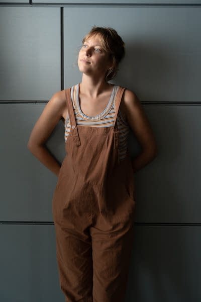 A woman poses for a portrait by a steel-panel wall