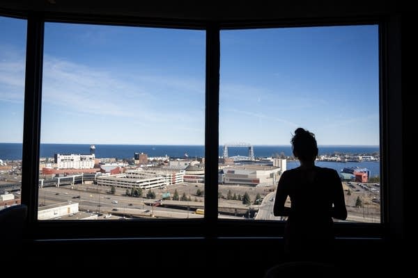 A woman looks out over the lakeshore and city scene of Duluth.