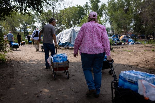 Volunteers carry bottled waters in hand carts