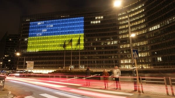 The headquarters of the EU Commission is lit up in blue and yellow in February 2023.