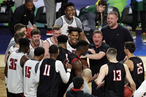 Texas Tech head coach Chris Beard laughs with his players in a huddle