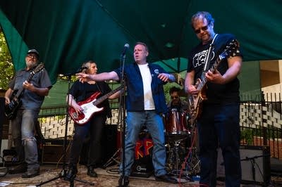 a rock band performing on an outdoor stage