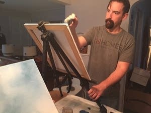 Justin Miller works on a painting.
