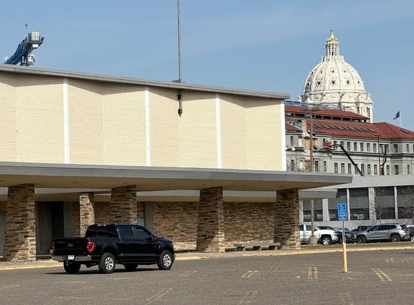 Exterior of a tan cement and brick building that formerly housed a Sears store.