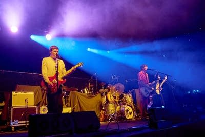 Four musicians performing together onstage