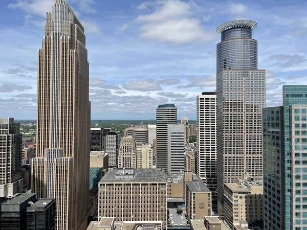 Several tall buildings in a city on a partly cloudy day