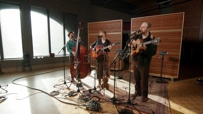 Three musicians performing together in a recording studio