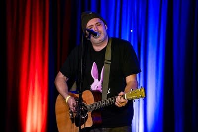 A musician performing onstage in a music venue
