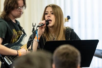 A student holds a mirophone to sing.