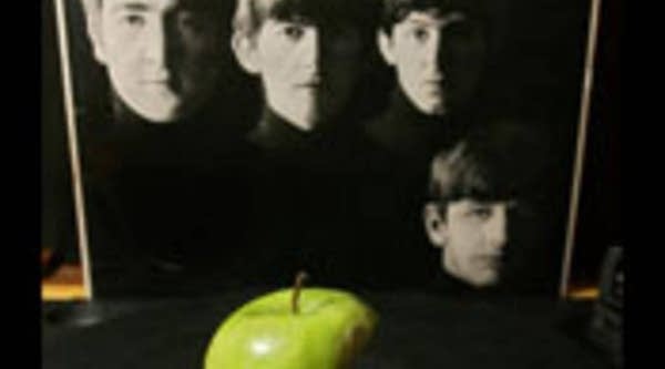 An apple is placed on a turntable against a background image of the Beatles in London, 05 April 2006. Apple computer defended its right Wednesday to use the apple logo when promoting its own iTunes music service.