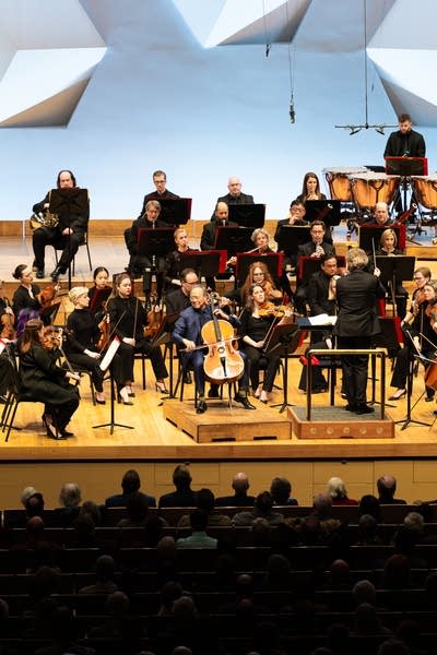 An orchestra performing onstage in a large music hall