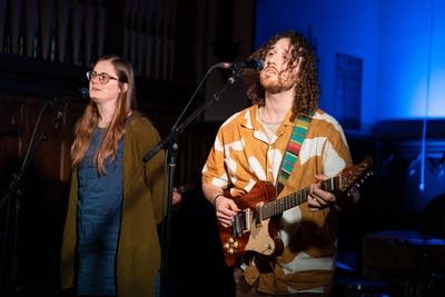Two people singing into microphone