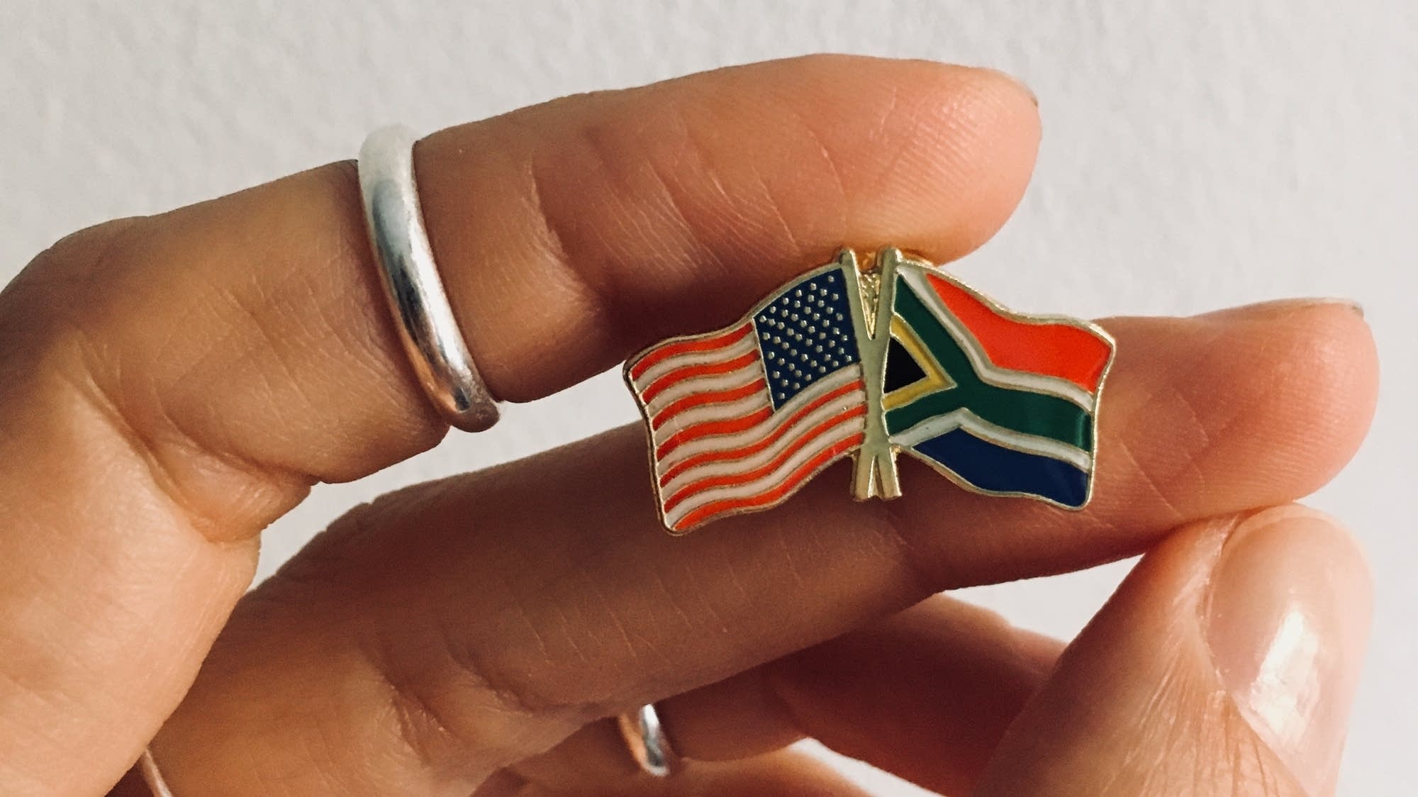 Dessa holds a pin showing the U.S. and South African Flags