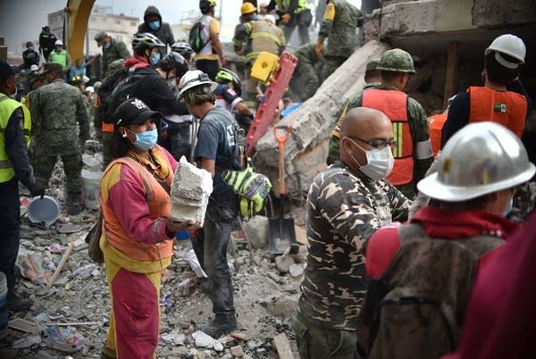 Volunteers remove rubble during the search for survivors.