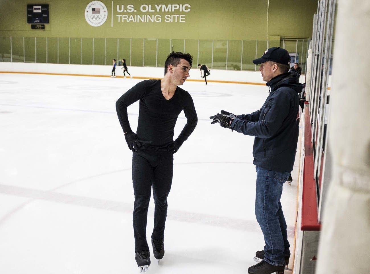 Max Aaron talks with his coach, Tom Zakrajsek, during practice