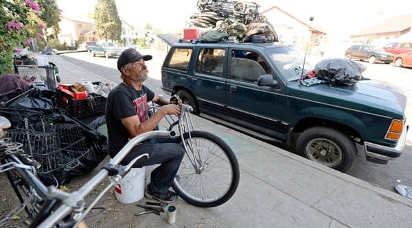 A homeless man for over 30 years, who lives inside his car, repairs a bicycle on Sept. 23, 2015 in Hollywood. 