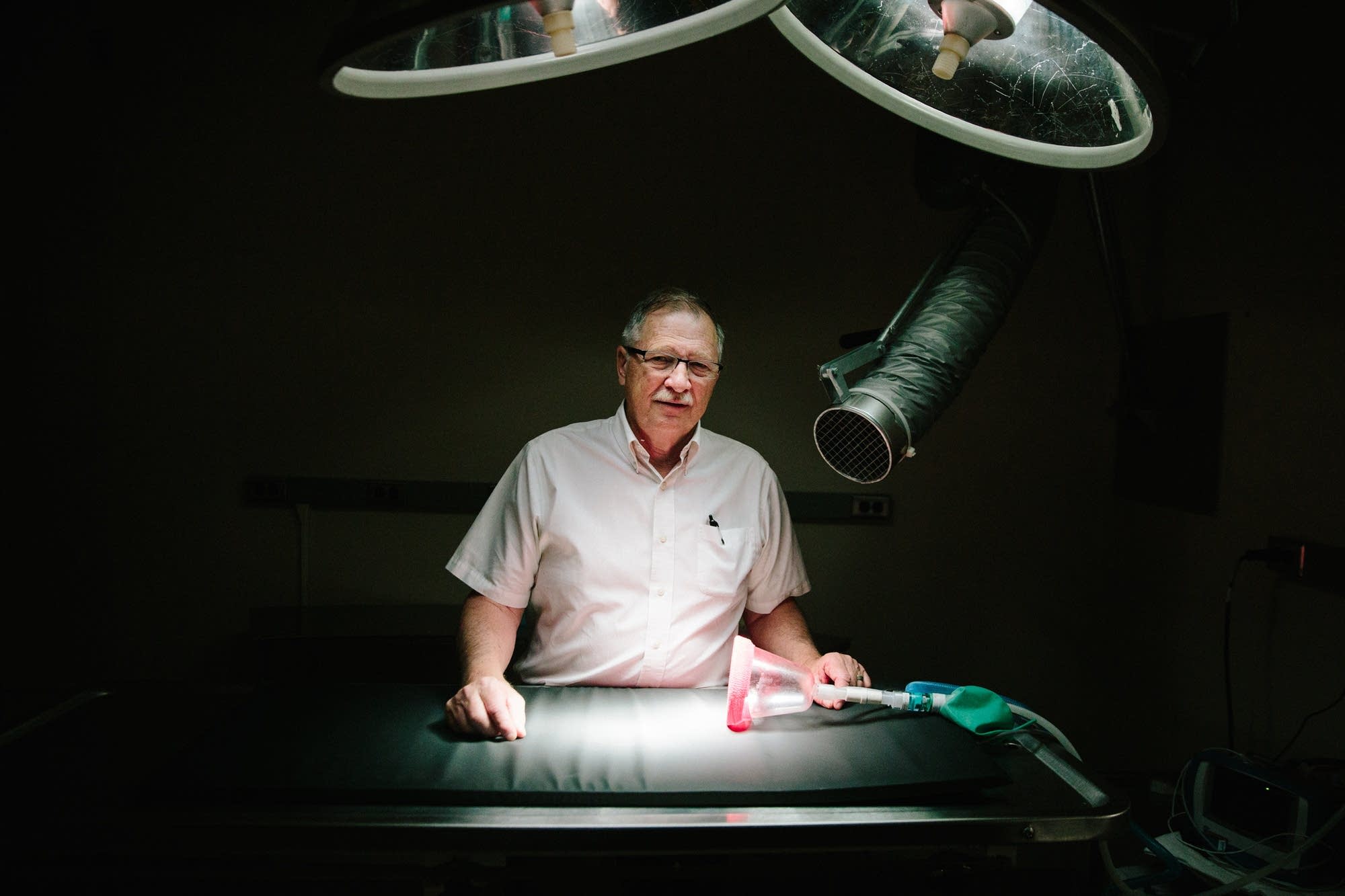 Dr. Patrick Redig stands for a portrait next to an operating table.