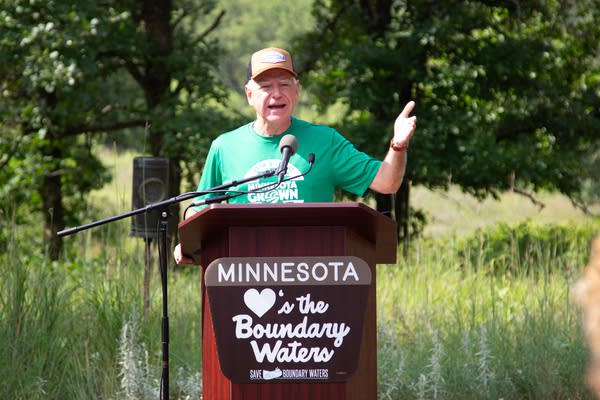 A man stands at a podium that reads "Minnesota Loves the Boundary Waters."