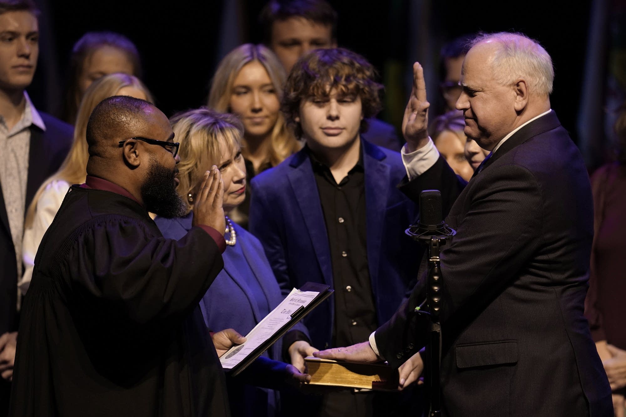  Two people raise their hands at a ceremony