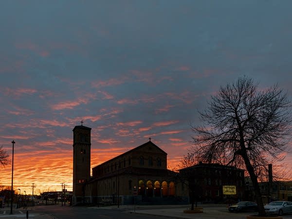 A silhouette of a building against a purple and orange sunset