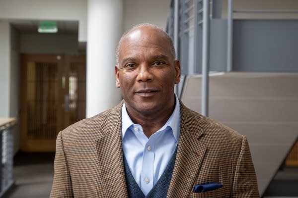 Man in brown suit posing for photo