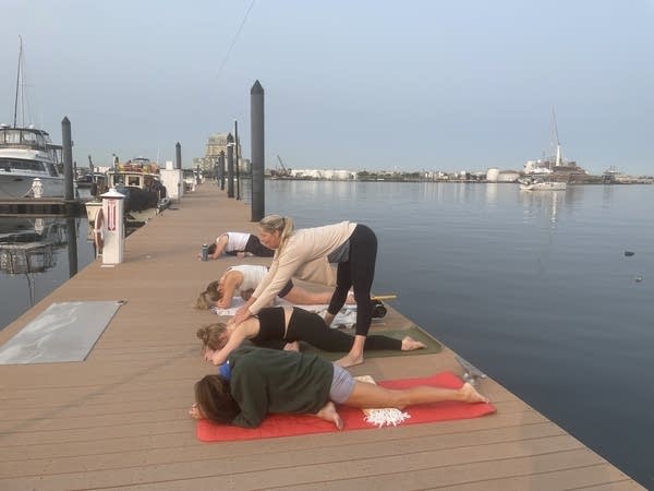 Jessie Benson (standing) leads a yoga class on the Baltimore waterfront.