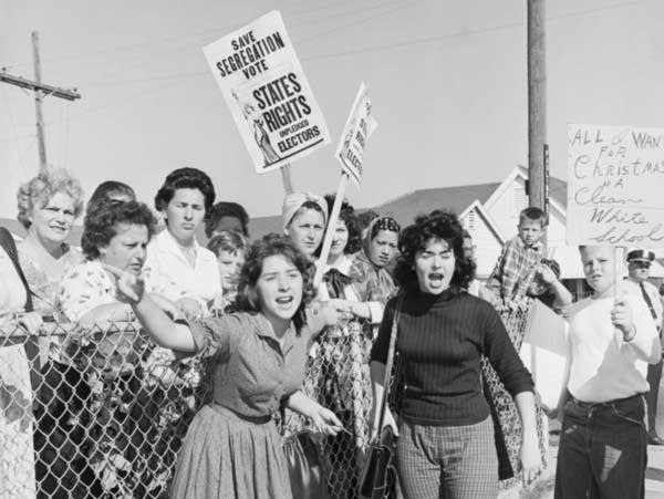 A black and white photo of protestors holding signs.