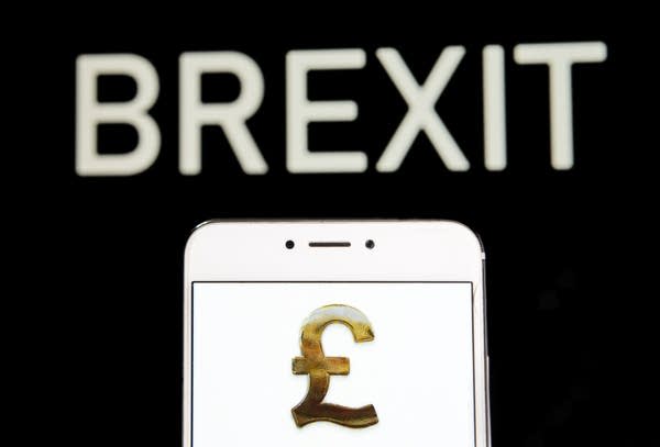 Photo illustration of Great Britain's currency Pound Sterling icon is seen on an Android mobile device with a Brexit message in the background.
