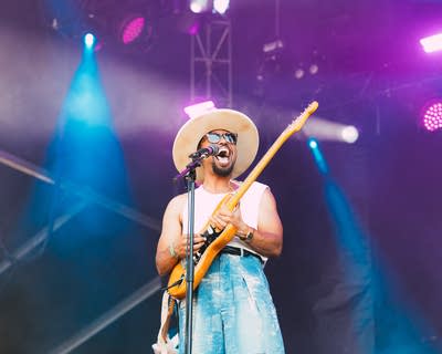 Devon Gilfillian performing with a guitar on stage