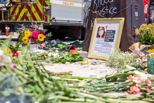 Flowers surround a poster of a woman.