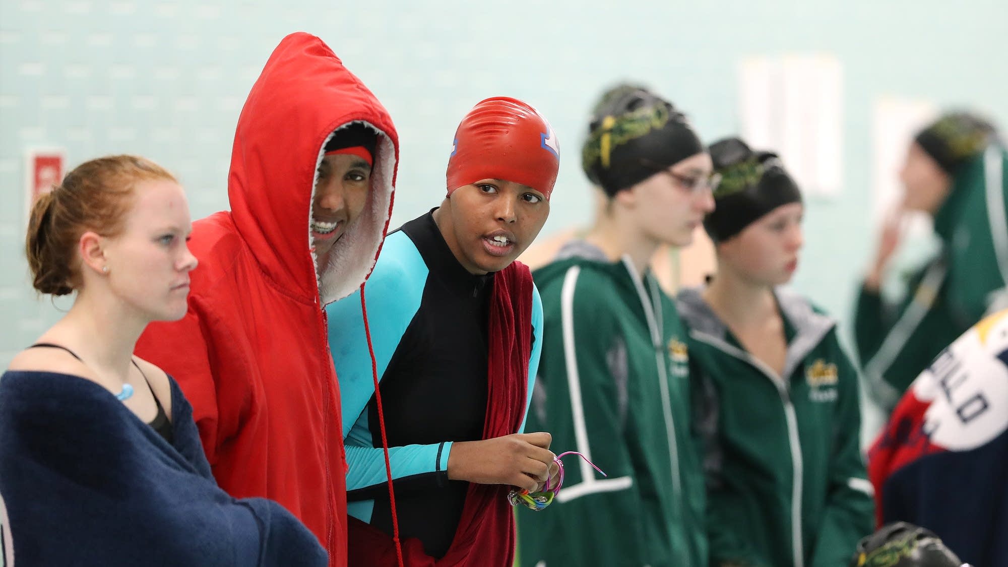 Nimo Gohe, in red jacket, and Mohamed cheer on their teammates.
