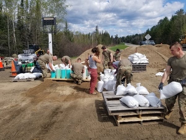 National Guard members and volunteers fill sandbags