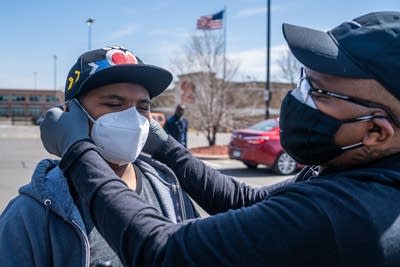 A man puts a mask on his son.