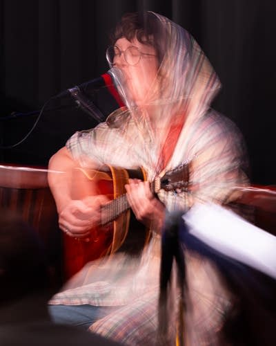 Lambchop performs seated on a stage.